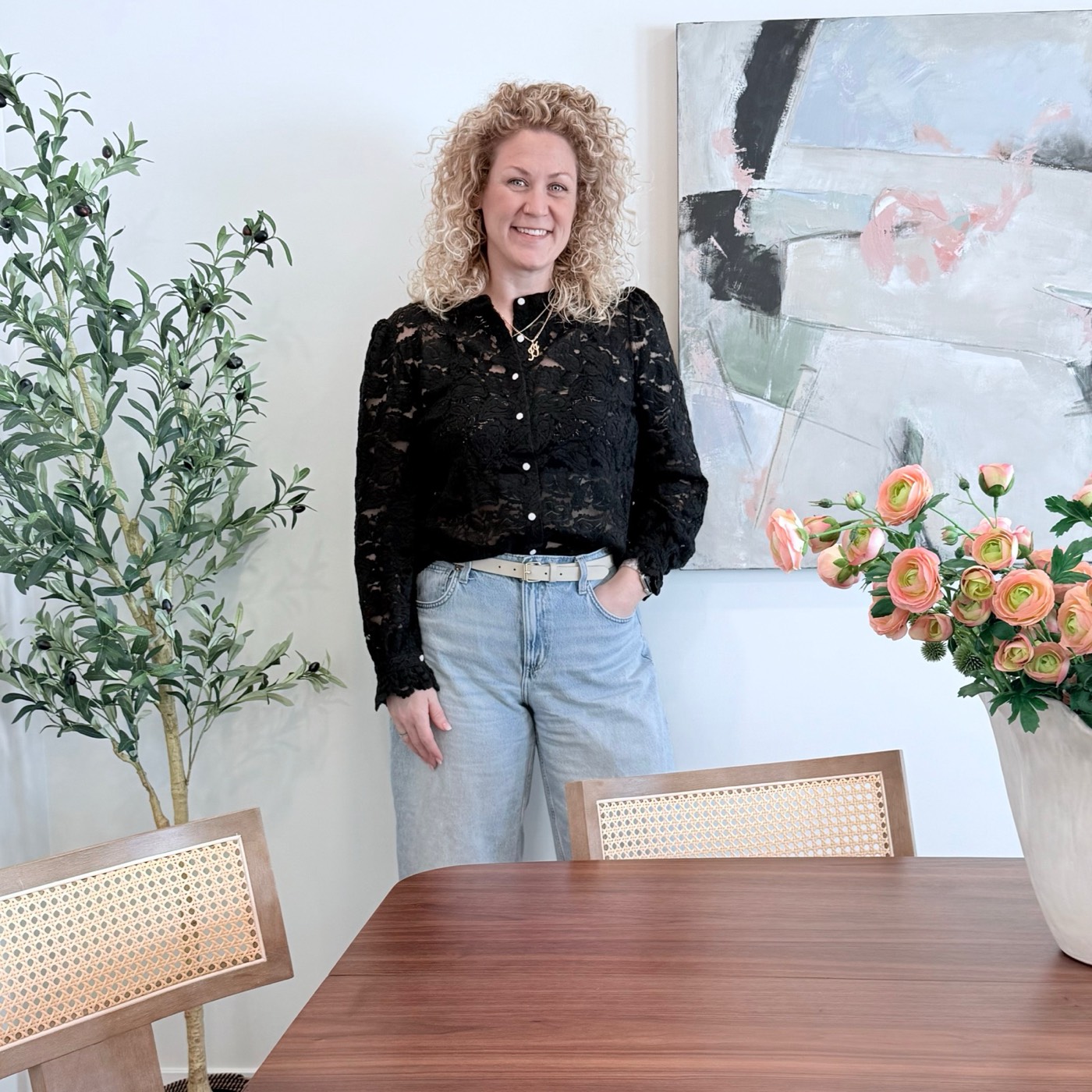 Aimée Lauren Leslie, Owner and Lead Interior Stylist, beside one of her original paintings